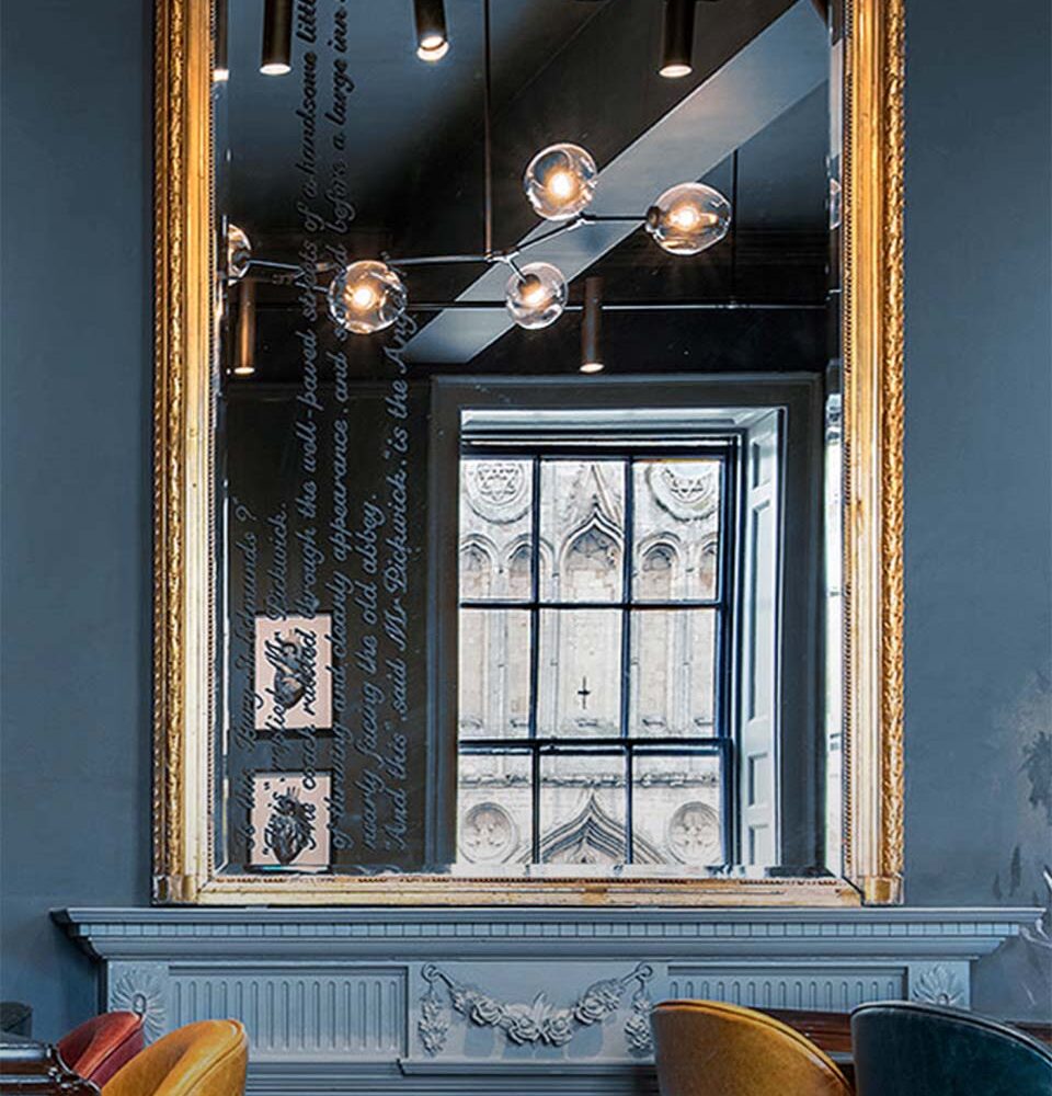 a mirror with text written on it, reflecting a window.