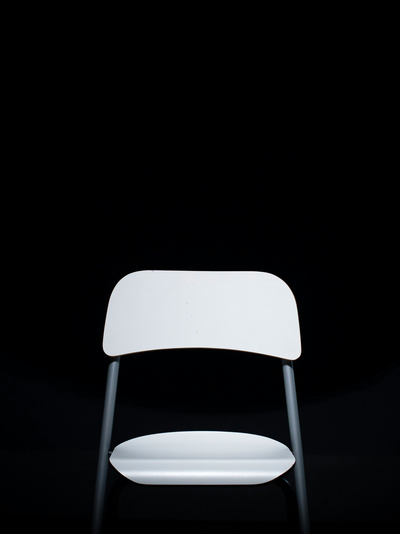 white chair on black backrground.