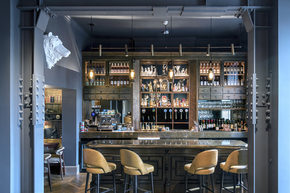 The bar now glows with layered warmth, transformed from a vintage jewellery counter into a showstopping bronze-topped centrepiece